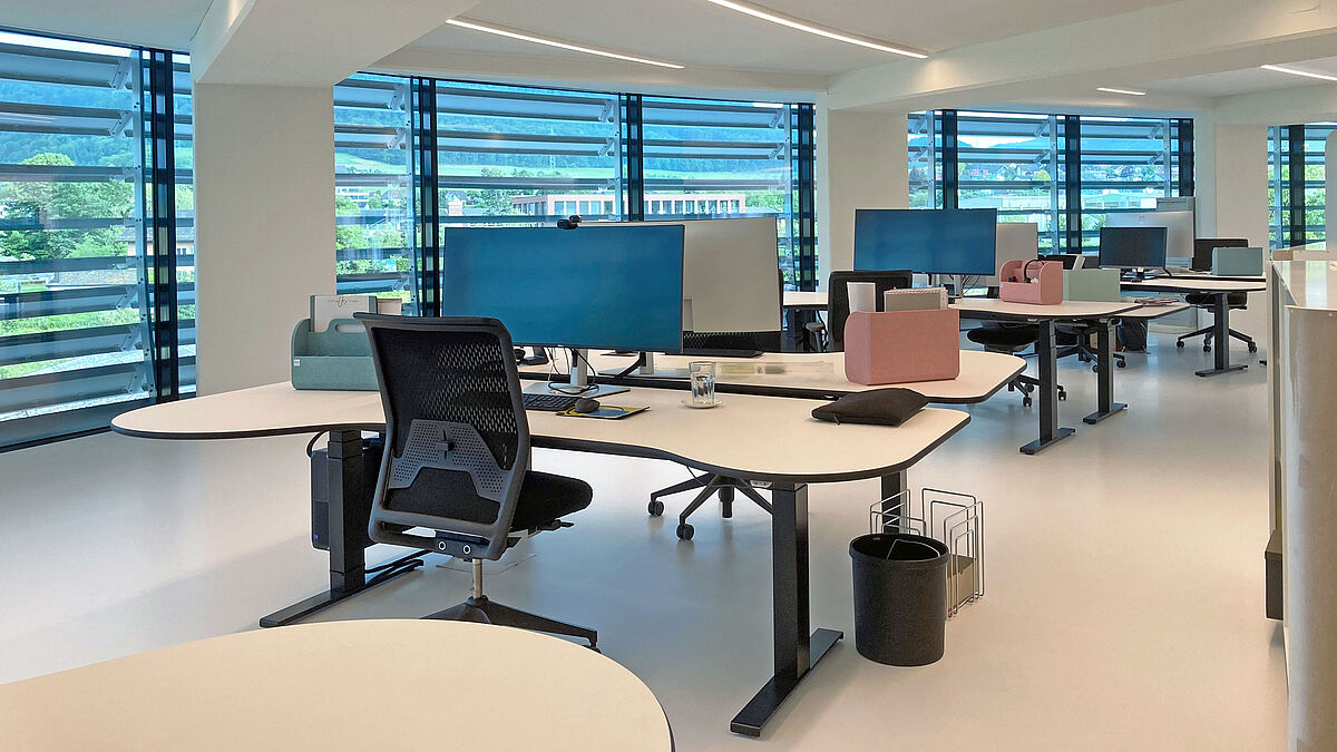 Im äusseren Ring befinden sich 20 mobile und modern eingerichtete Doppelarbeitsplätze. Mit Tablets und flexibler Infrastruktur können sich Mitarbeitende überall im Büro einloggen.  Bild: Bäumlin+John AG