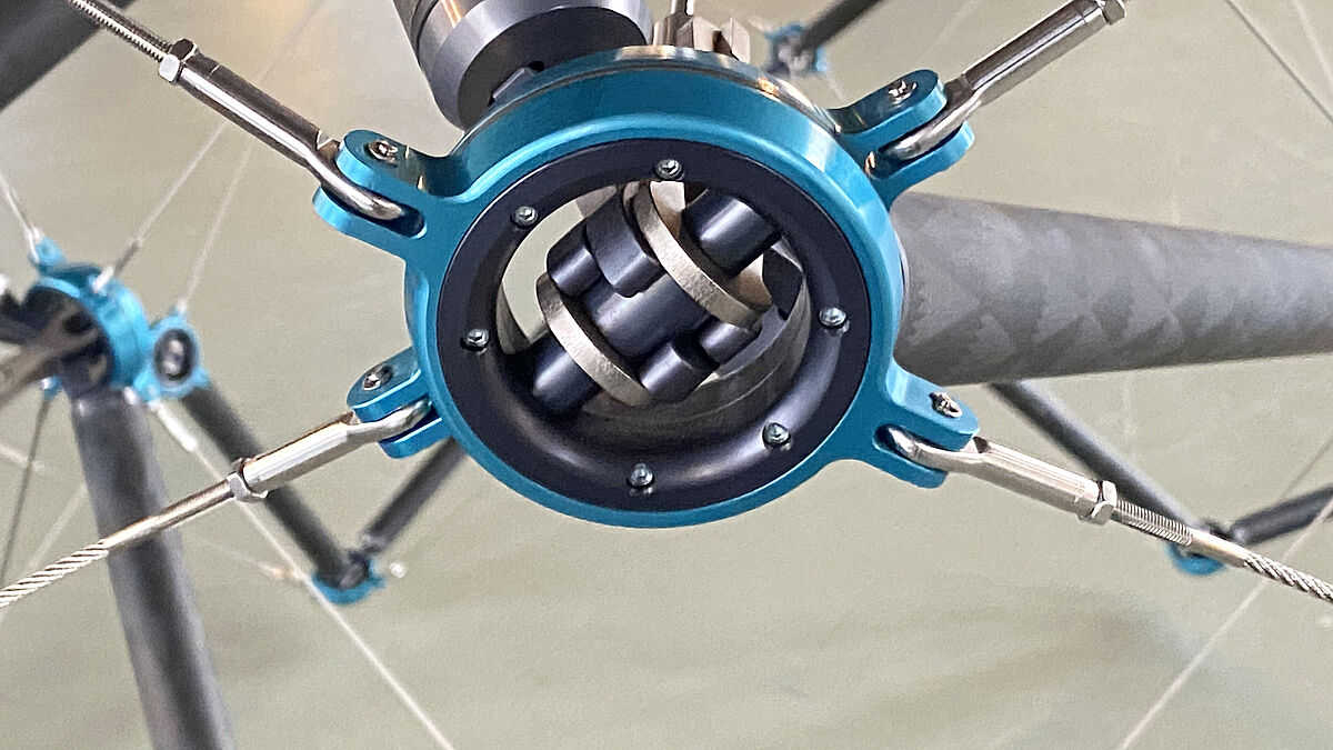 Ausgeführtes Verbindungselement. In jedem Element laufen vier spiralförmig angeordnete Seile, ein Seil mit radialem System und zwei Stäbe zusammen.