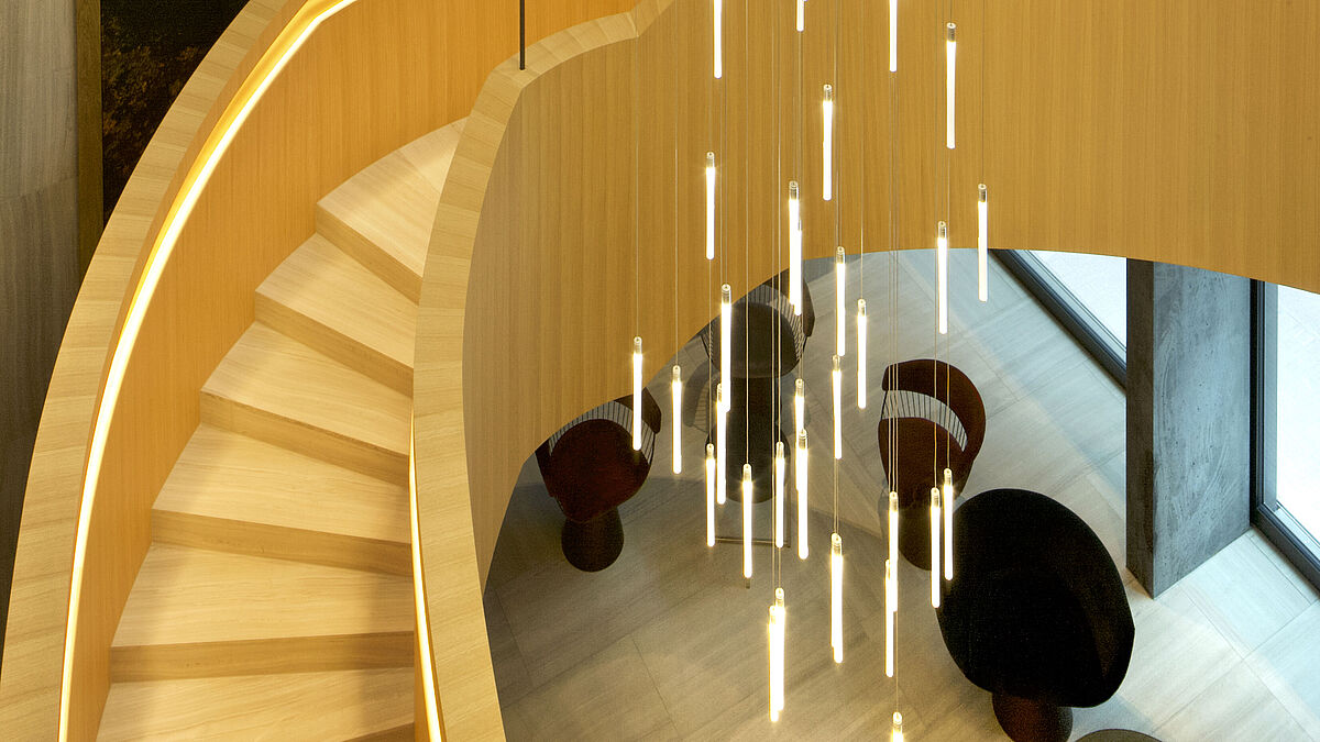 Zusätzlich zur Eigensteifigkeit der Stahlkonstruktion wird die Treppe von vier Zugstangen, die an der Decke befestigt sind, gehalten.