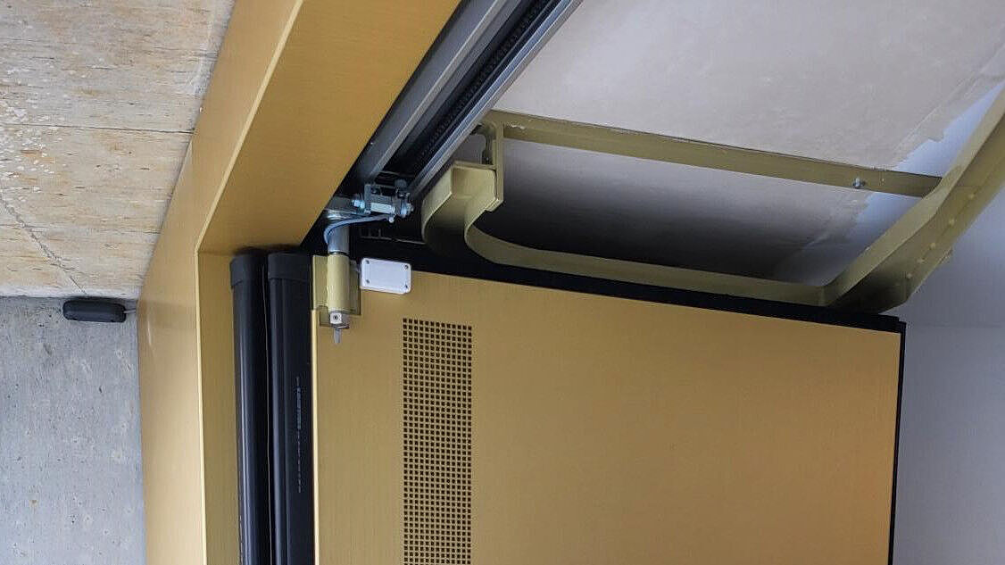 Das schwellenlose Tor im offenen Zustand. Im Bereich der Trag- und Führungsrollen waren entsprechende Ausschnitte in den Verkleidungsblechen erforderlich.