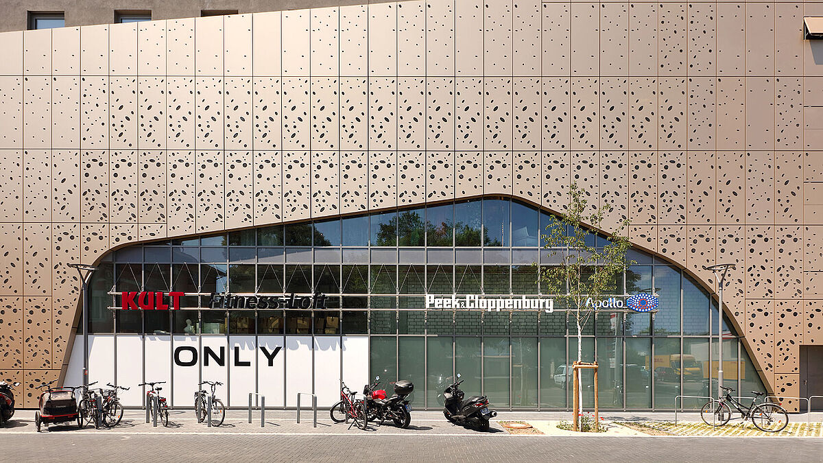 Verglaste Pfosten-Riegel-Konstruktion umgeben von gelochten Aluminiumpaneelen.