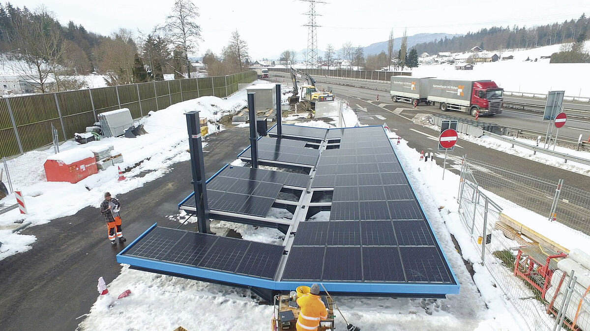 La structure en acier est assemblée et les modules solaires reposent dans le cadre. Le tout est prêt à être levé.