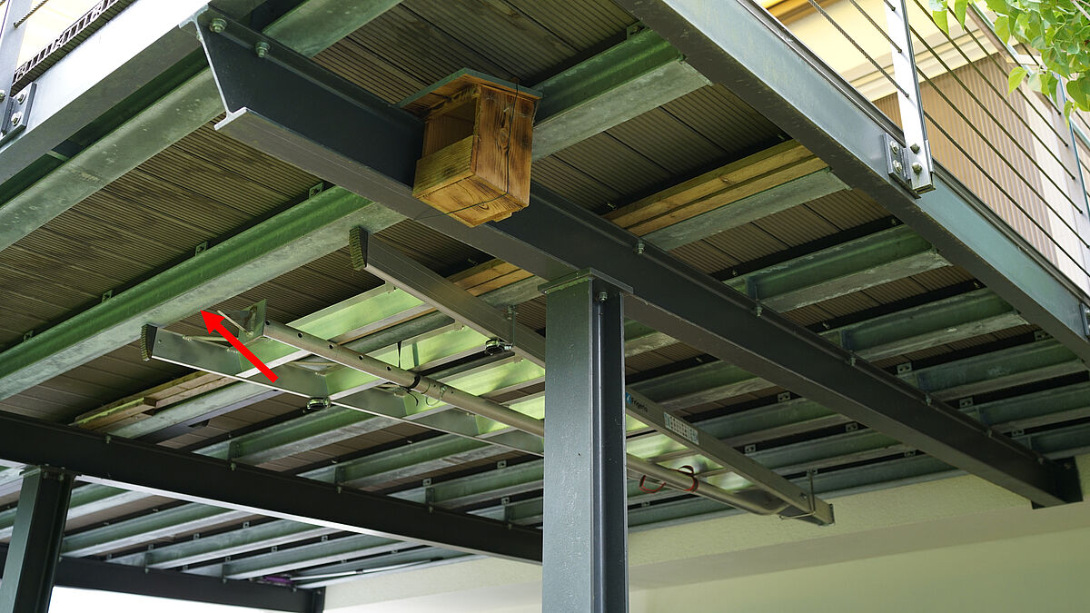 Falsch: Der rote Pfeil zeigt den seitenverkehrten Längsträger. Dieser verhindert die Ausdehnung des Terrassenbelags in Richtung Garten.