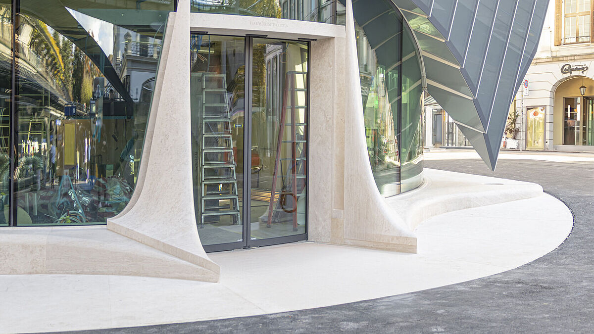 Im Erdgeschoss bildet eine Rundbogenverglasung den unteren Abschluss der Fassade, die zu den stirnseitigen Eingängen ausgerichtet ist.