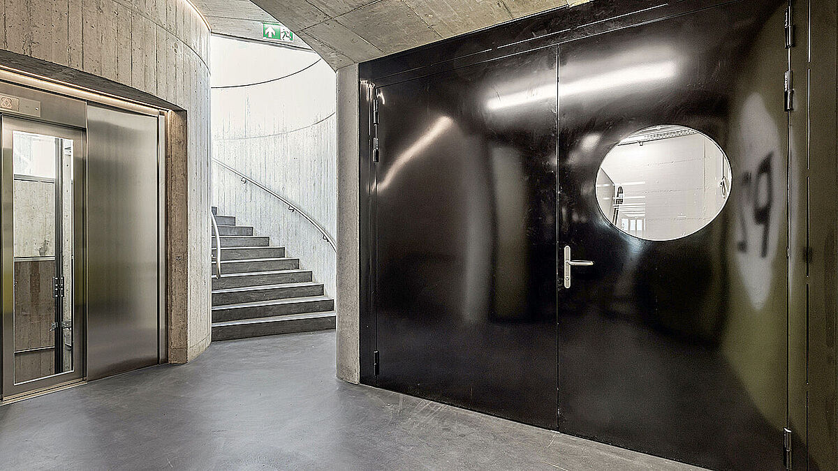 Als Verbindungstür zwischen zwei Trakten des Parkhauses ist eine zweiflügelige Brandschutztür des Systems Forster Presto E30 mit Vollblech-Flügeln sowie einem markanten Rundfenster im Gehflügel verbaut.