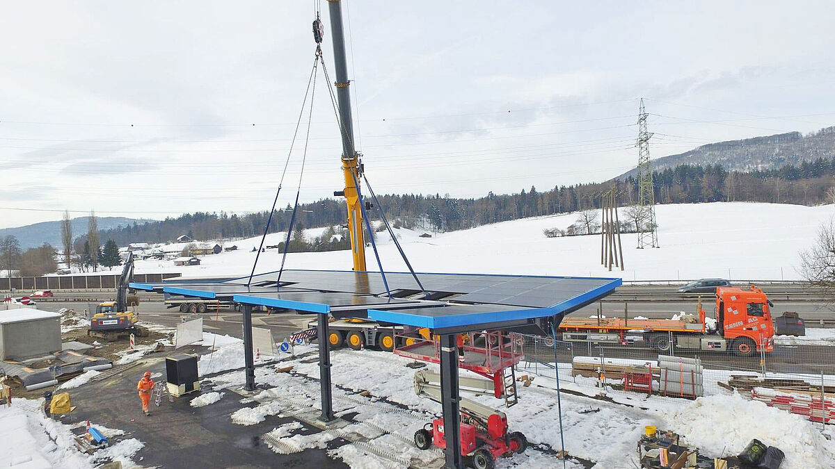 Le toit d’environ 12 tonnes est soulevé et vissé sur les trois poteaux.