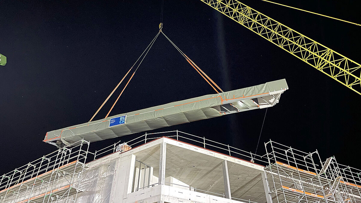 Optimal ausbalanciert wird das 20 Tonnen schwere Werk über den Rohbau an den Zielort gehievt.