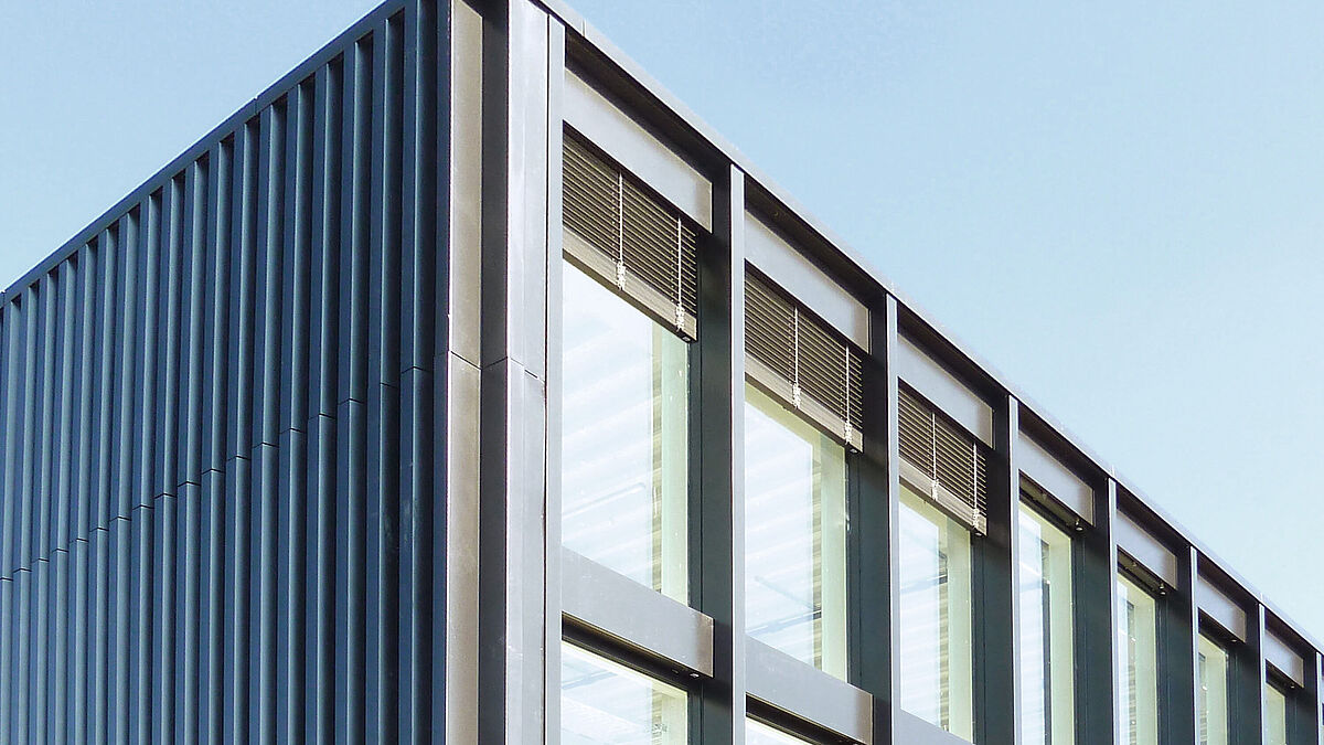 Angle de la façade sud-ouest : les tôles profilées en V remplacent la partie transparente.