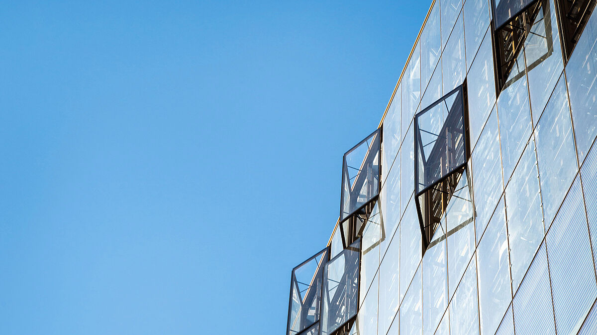 Die unregelmässig versetzten Elemente der zweischaligen Fassade sind an zahlreichen tragenden Stahlpfosten befestigt, die mehrere Geschossebenen überspannen.