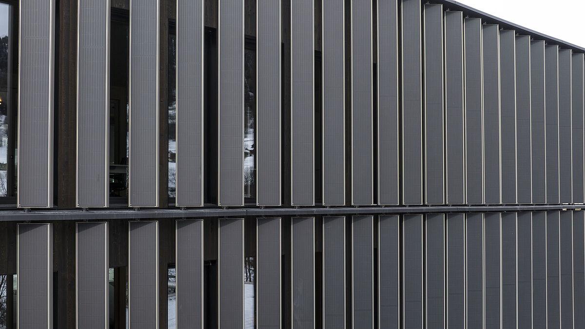 Hinter den Lamellen befindet sich die Warmfassade aus Holzfenstern und Wärmeschutzglas.