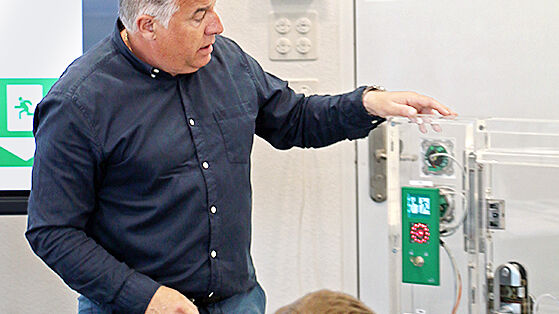 Der Fachdozent erklärt die verschiedenen Komponenten eines Fluchttürsystems.