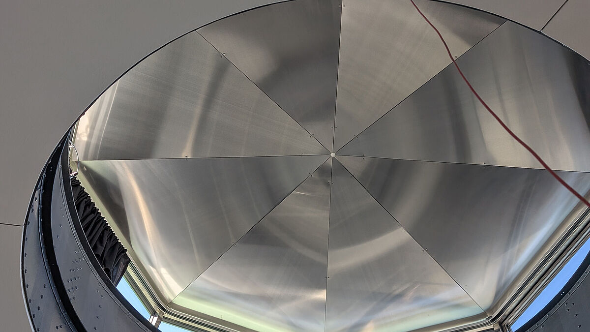 Untersicht Kuppeldach: die Verkleidungsbleche aus Edelstahl breiten sich vom Zentrum her strahlenförmig aus. Die denkmalgeschützte Unterkonstruktion mit ihren vernieteten Blechen blieb bestehen. Bild Surber Metallbau AG   Im Print weglassen!